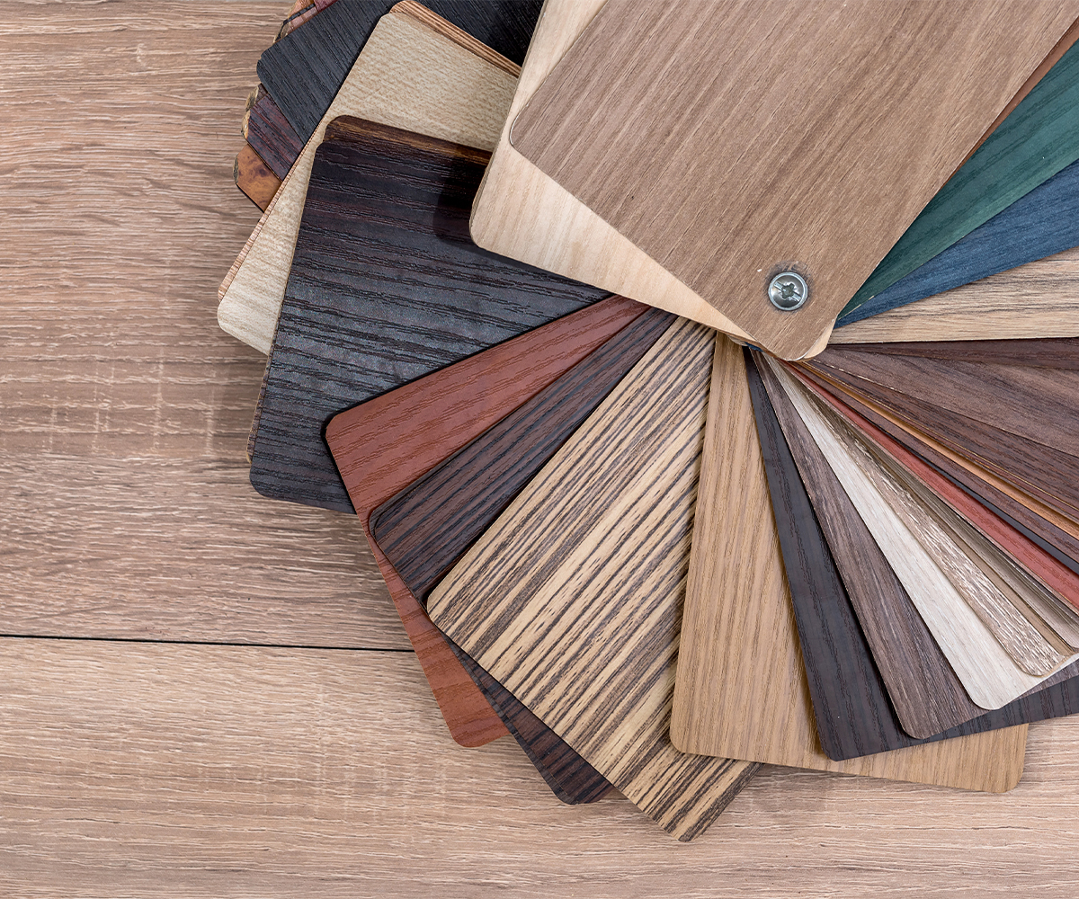 Fan of wood stain and finish samples spread on a tabletop.